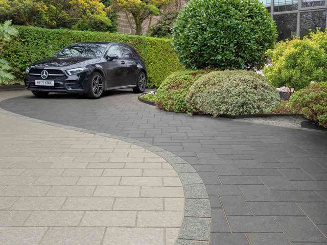 Block-paved driveway with car parked outside a house
