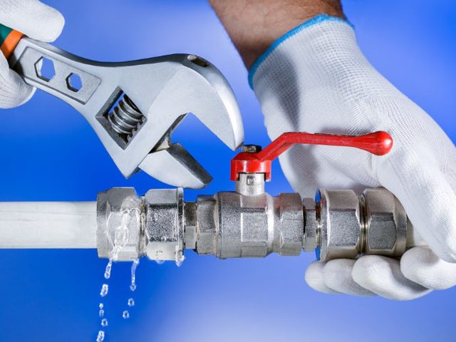 Plumber fitting a valve on a copper pipe